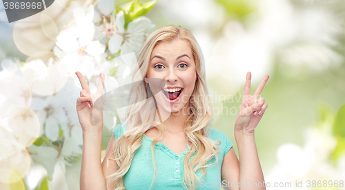 Image of smiling young woman or teenage girl showing peace