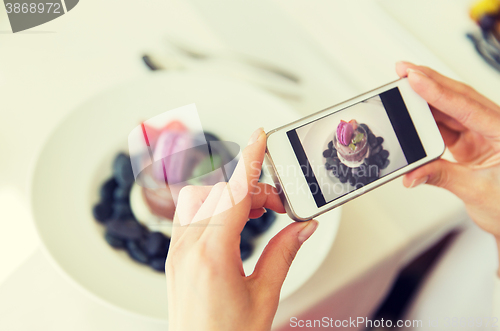 Image of close up of woman picturing food by smartphone