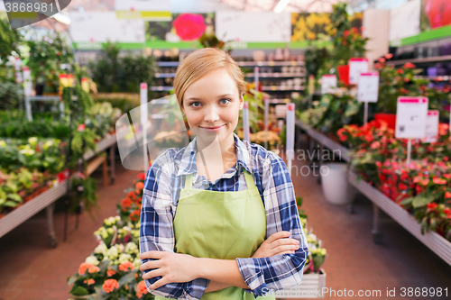 Image of happy woman with flowers in greenhouse