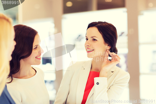 Image of happy women choosing earrings at jewelry store