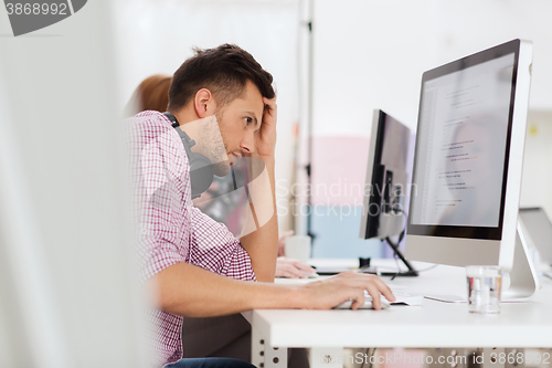 Image of stressed software developer at office