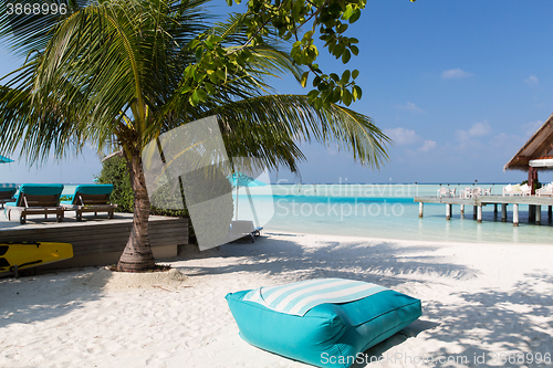 Image of parasol and sunbeds by sea on maldives beach