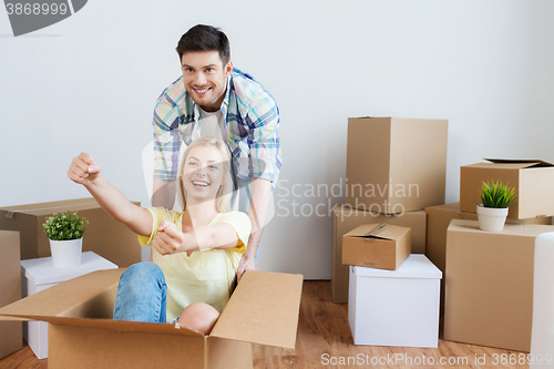 Image of happy couple having fun with boxes at new home