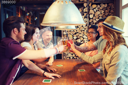 Image of happy friends drinking beer at bar or pub