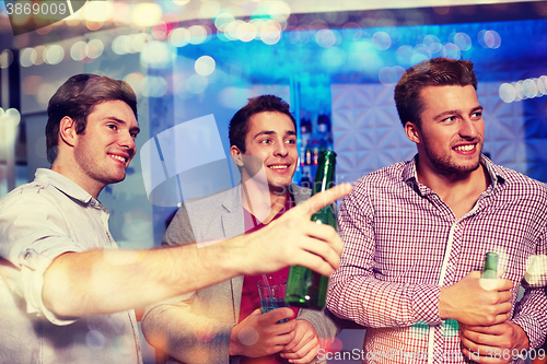 Image of group of male friends with beer in nightclub