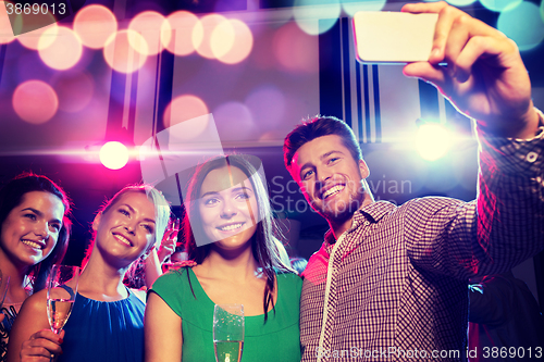 Image of friends with glasses and smartphone in club
