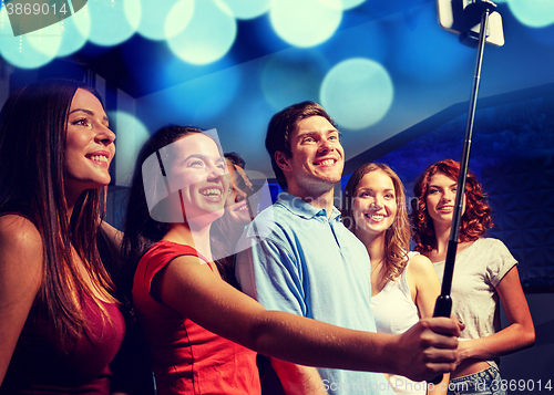 Image of friends with smartphone taking selfie in club