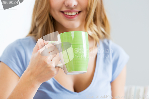 Image of happy woman or teen girl drinking tea from cup