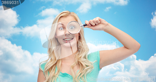 Image of happy young woman with magnifying glass