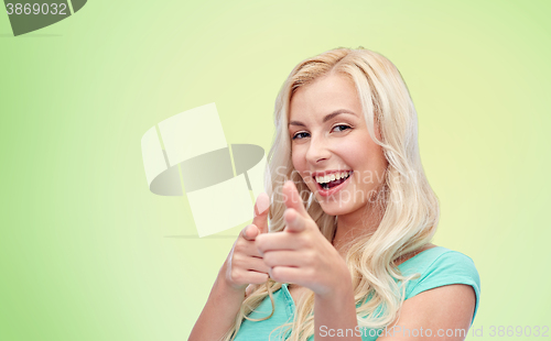 Image of happy young woman pointing finger to you