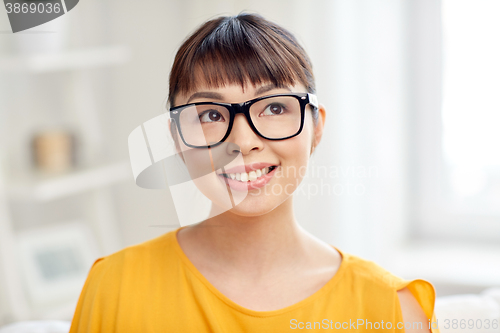 Image of happy asian young woman in glasses at home