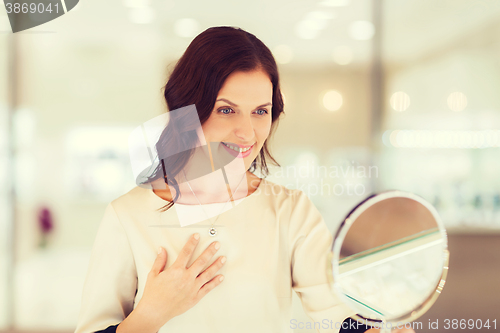 Image of happy woman choosing pendant at jewelry store