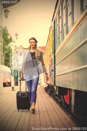 Image of woman with luggage rushing on train