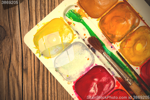 Image of watercolors, paint-box and a brush