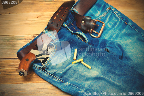 Image of old blue jeans with silver revolver in his pocket