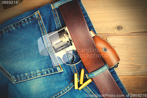 Image of silver revolver nagant in the pocket