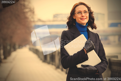 Image of beautiful middle-aged woman wearing glasses with a laptop