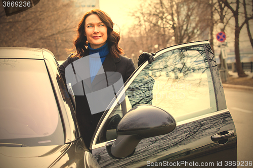 Image of beautiful businesswoman near car