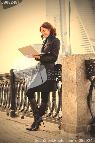 Image of smiling middle-aged woman with a laptop