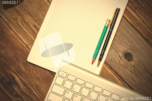 Image of Computer keyboard, notebook and pen