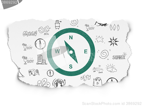 Image of Tourism concept: Compass on Torn Paper background