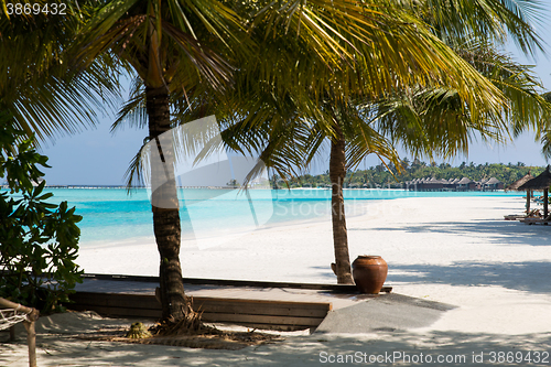 Image of bungalow huts in sea water on exotic resort beach