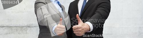 Image of businessman and businesswoman showing thumbs up