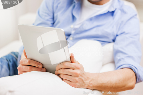 Image of close up of man working with tablet pc at home