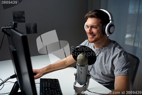 Image of man in headset playing computer video game at home