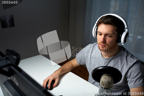 Image of man in headset playing computer video game at home