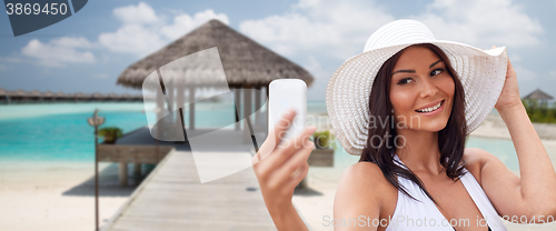 Image of young woman taking selfie with smartphone