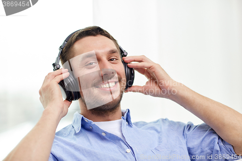 Image of smiling young man in headphones at home