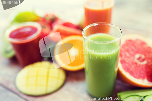 Image of close up of fresh juice glass and fruits on table