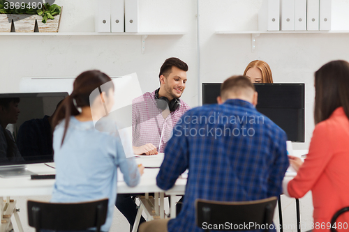 Image of happy creative team or students working at office