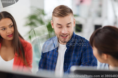 Image of happy creative team or students working at office