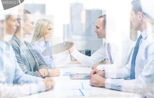 Image of businesswoman and businessman arm wrestling