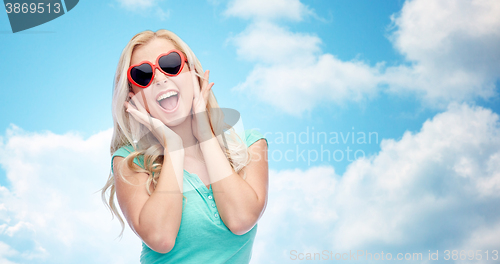 Image of happy young woman in heart shape sunglasses