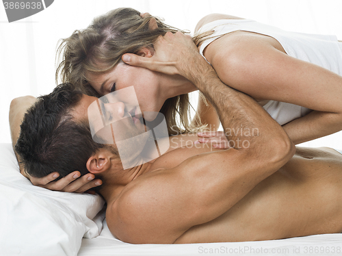 Image of attractive couple in love under white bed sheets