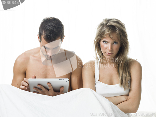 Image of uncommunicative couple on bed in white 