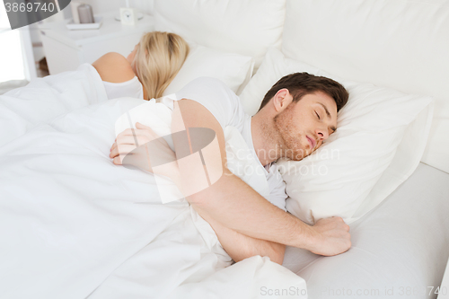 Image of couple sleeping in bed at home