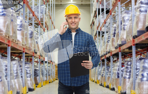 Image of man with clipboard and smartphone at warehouse