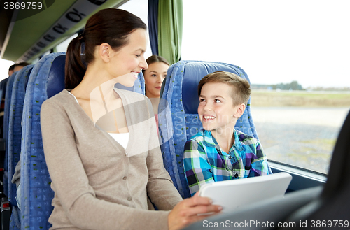 Image of happy family with tablet pc sitting in travel bus