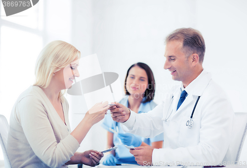 Image of doctor giving tablets to patient in hospital