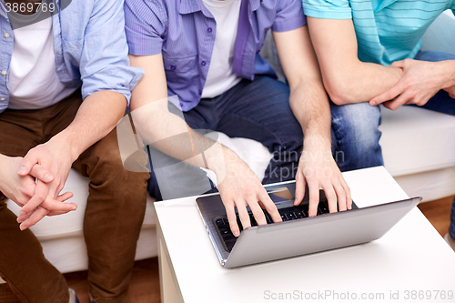 Image of close up of male friends with laptop at home