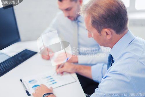 Image of businessmen with notebook on meeting