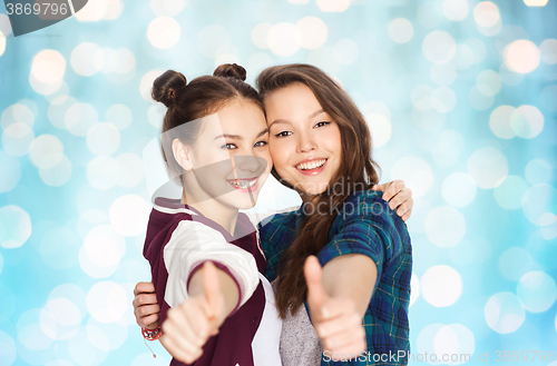 Image of happy smiling teenage girls showing thumbs up
