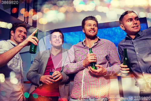 Image of group of male friends with beer in nightclub