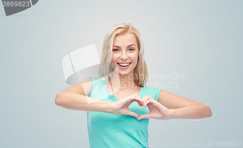 Image of happy woman or teen girl showing heart shape sigh