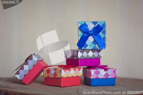 Image of Gift box with blue bow on wood background