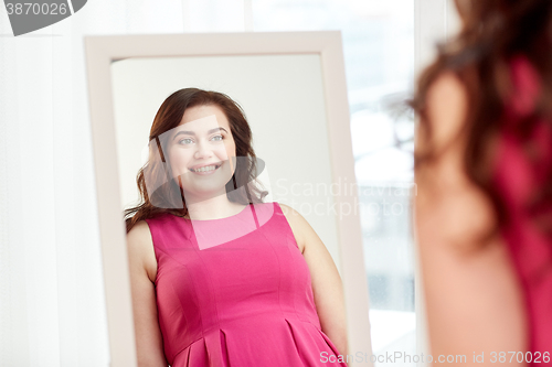 Image of happy plus size woman posing at home mirror